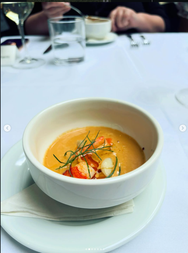 Illustrative orange soup with garnish in a white bowl